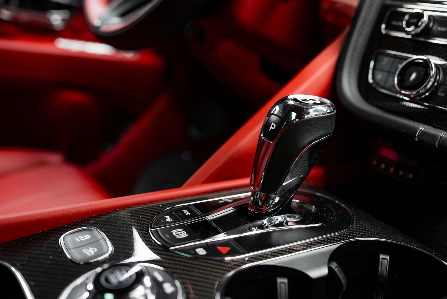 Detail shot of modern center console and controls in a Lamborghini with red leather trim.