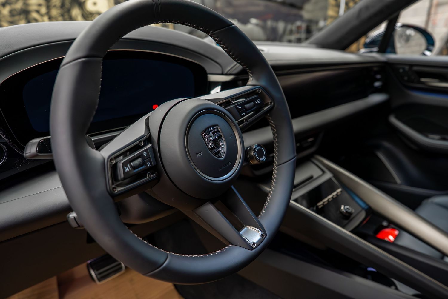 Interior dashboard and steering wheel details of luxury sports car in black leather.