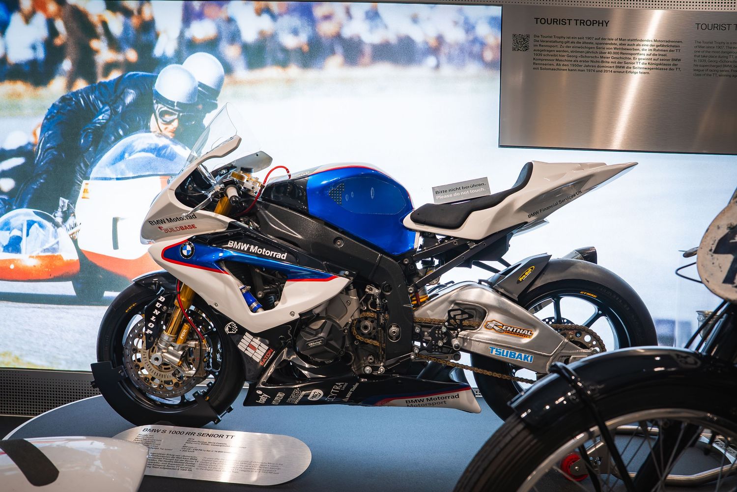 Line of BMW motorcycles displayed in a museum showing the evolution of bike design.