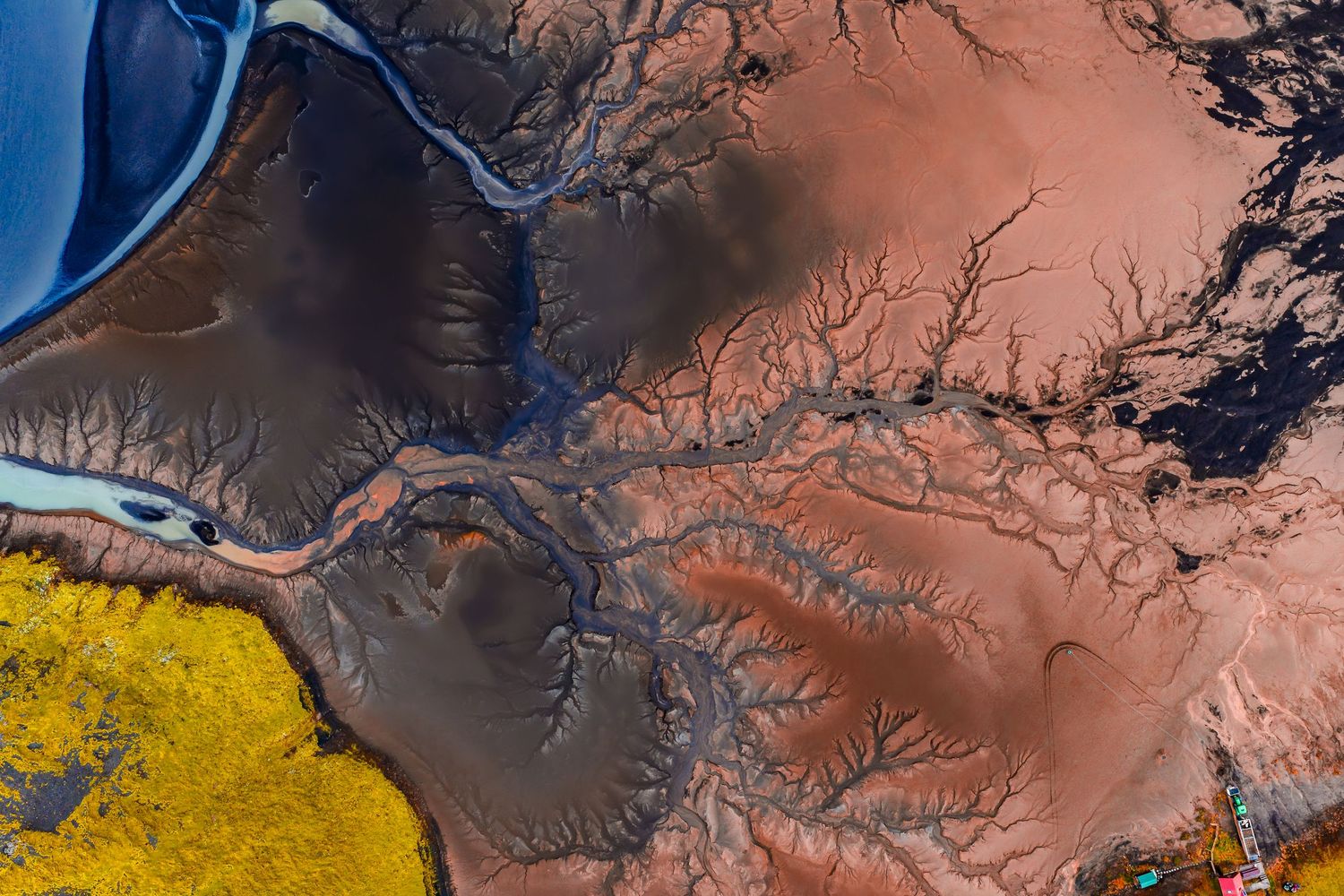 Aerial satellite view of colorful terrain patterns and landscapes with yellow, brown, and blue hues.