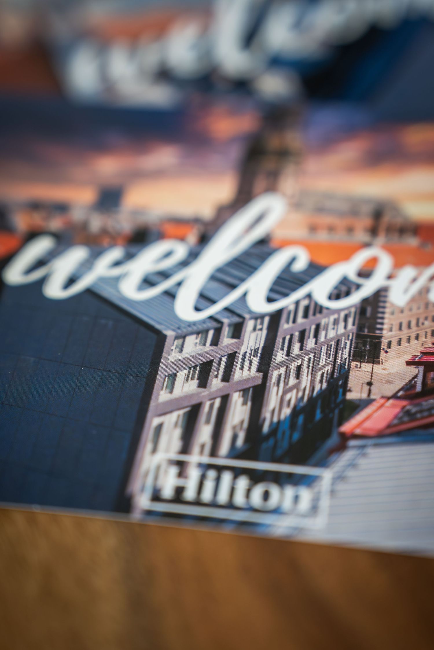 Artistic tilt-shift photo of welcome text with historic building architecture.