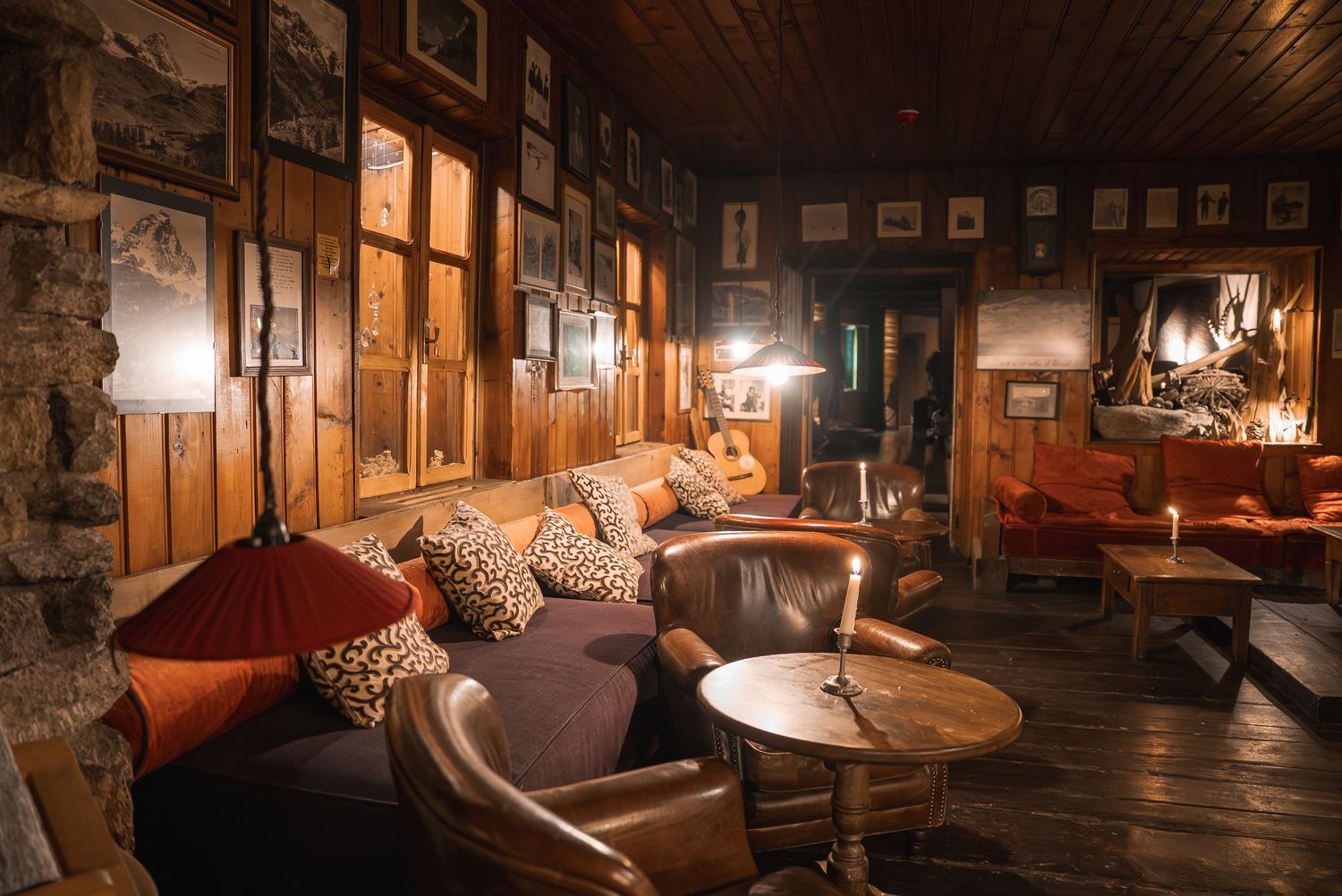 Intimate lounge area with leather seating and wooden walls in a rustic mountain lodge setting.