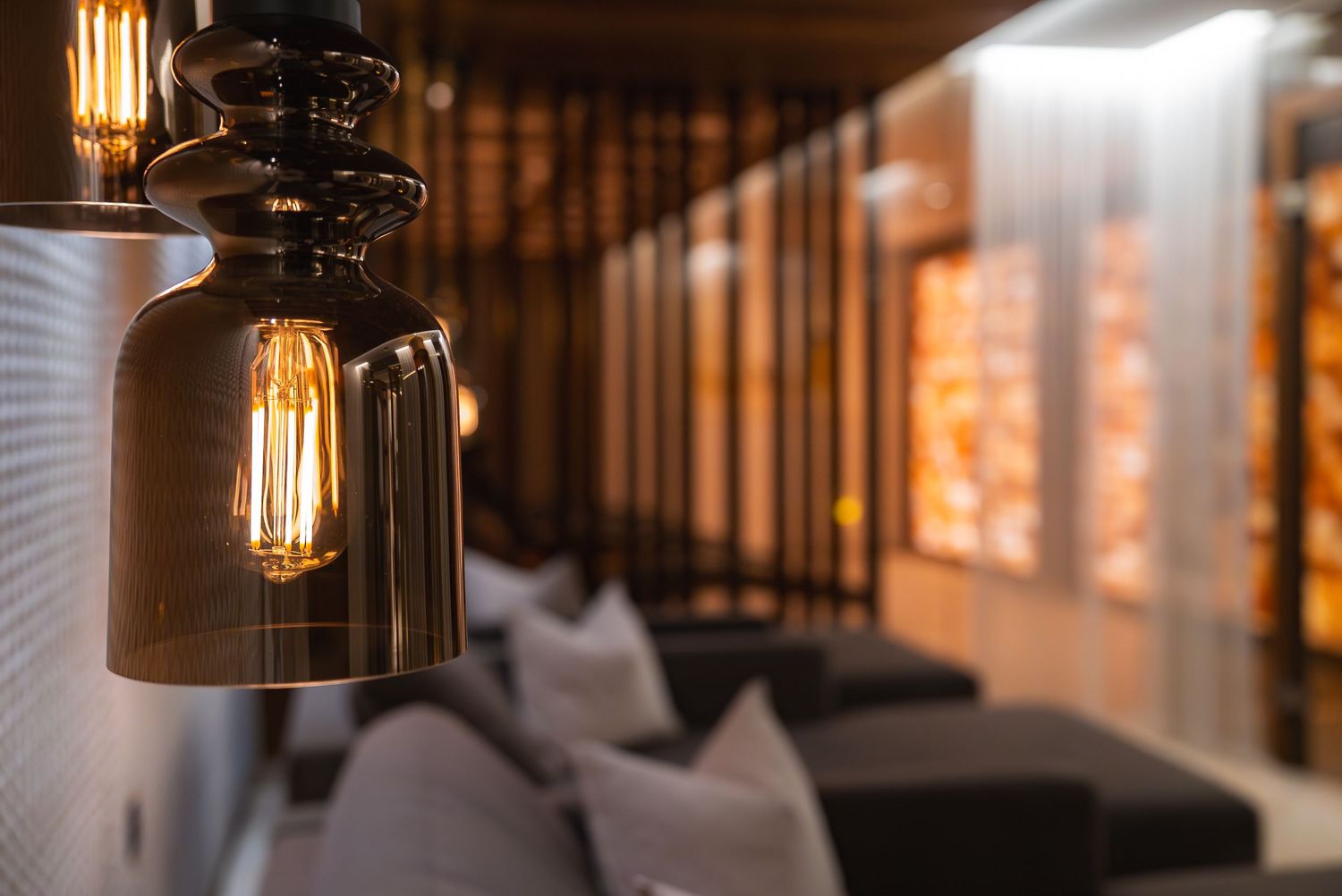 Industrial pendant lights with Edison bulbs hanging from wooden ceiling beams.