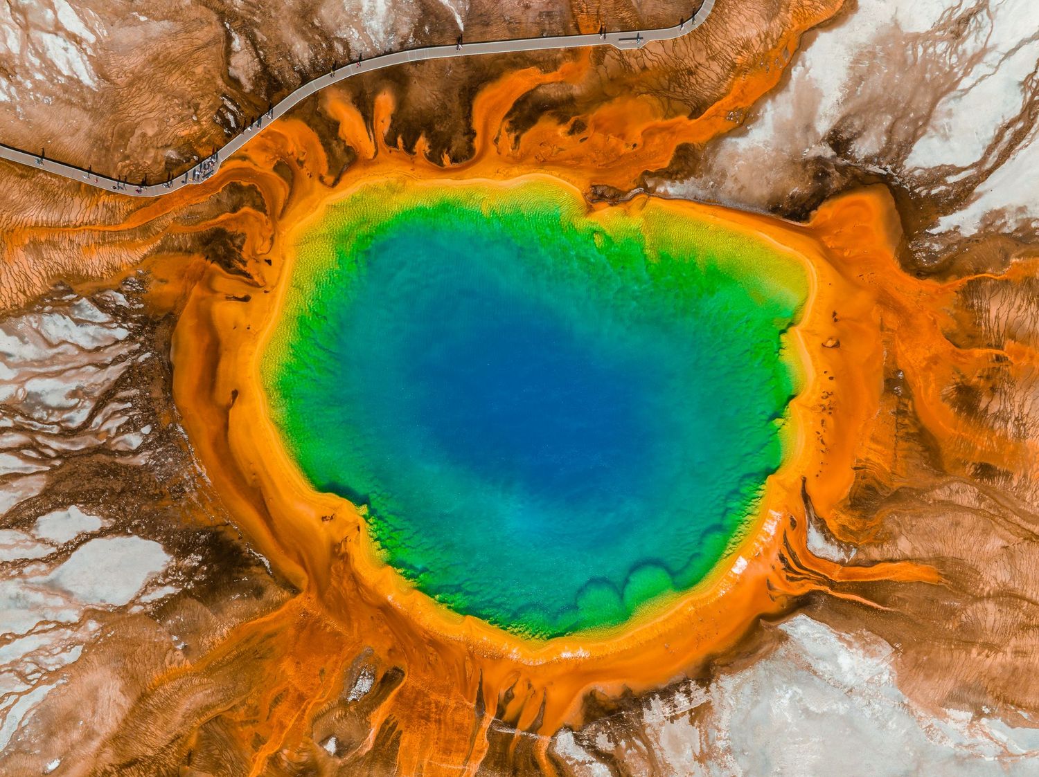 Aerial view of Grand Prismatic Spring in Yellowstone National Park showing vibrant blue, green and orange colors.
