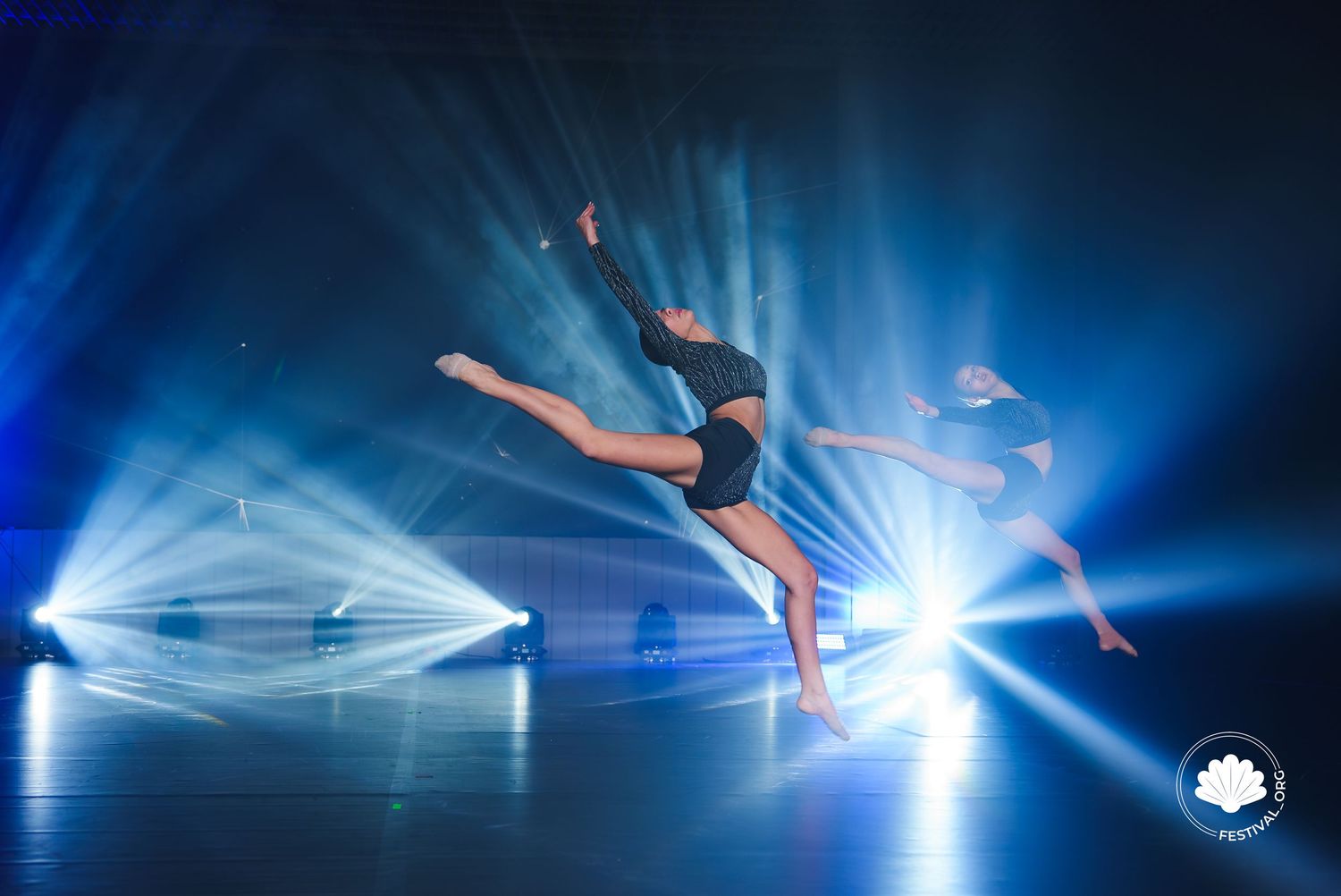 Modern dance performance with ethereal blue lighting and flowing movements.