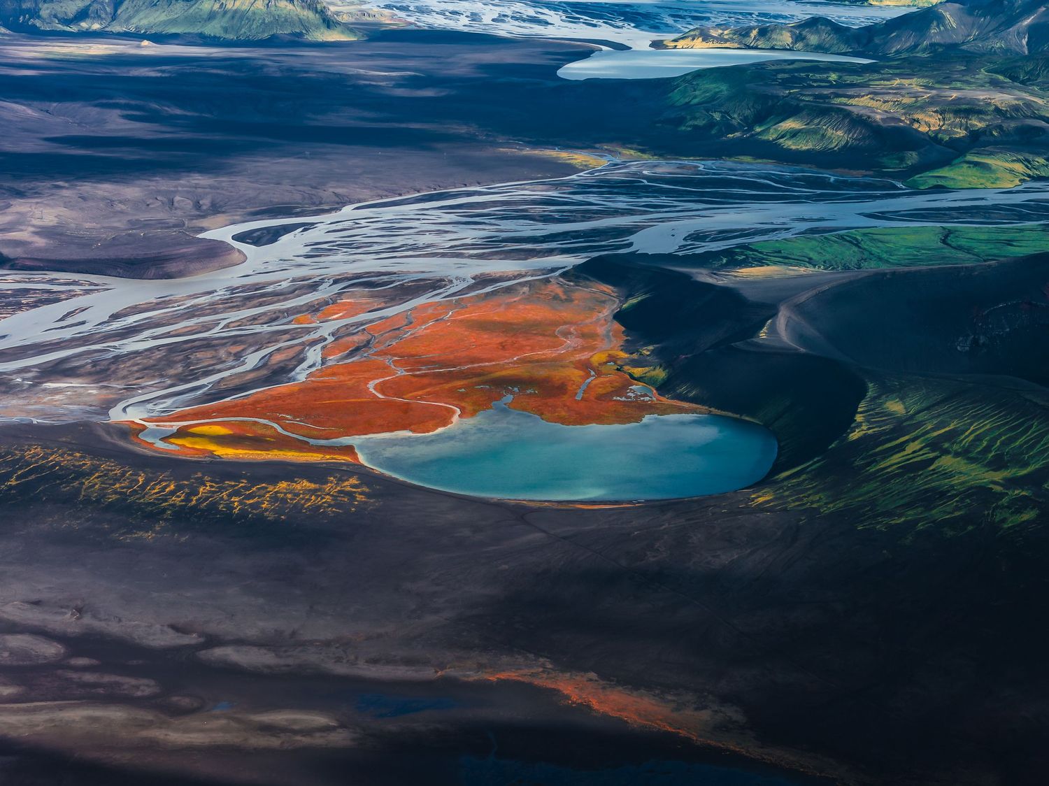 Aerial view of colorful mineral lakes and mountain landscapes in a remote wilderness region.