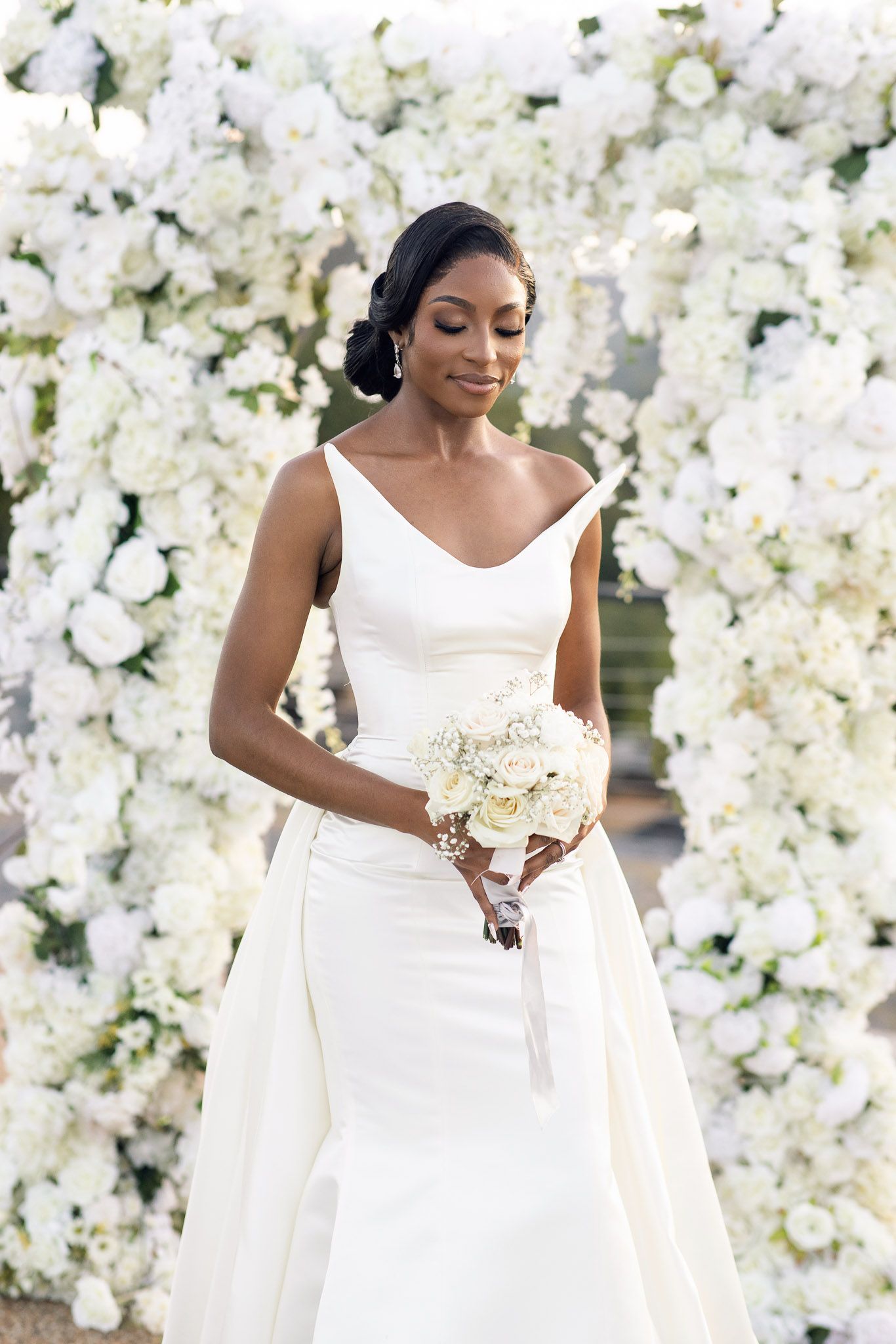 Elegant bridal portrait featuring a classic white wedding dress and delicate bouquet.