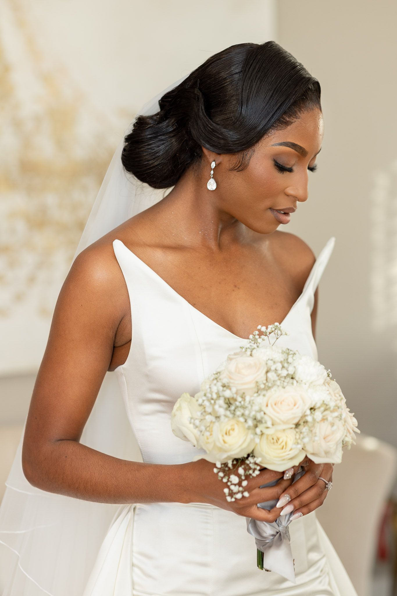 Close-up views of an elegant bride in a white wedding dress holding a bouquet of cream roses.
