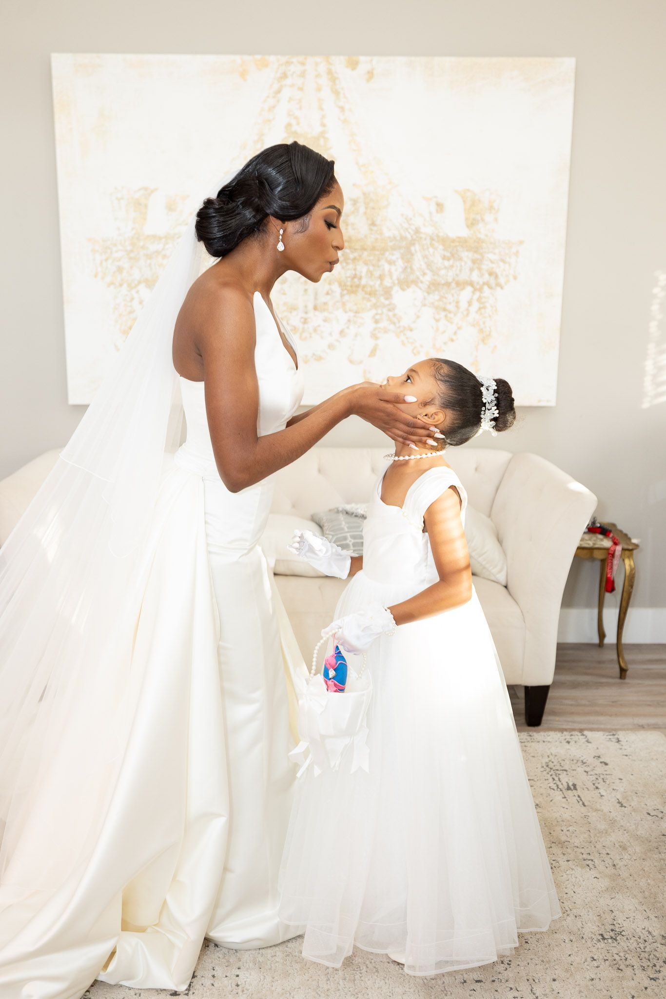 Sweet moment captured between two people in white dresses during wedding preparations.