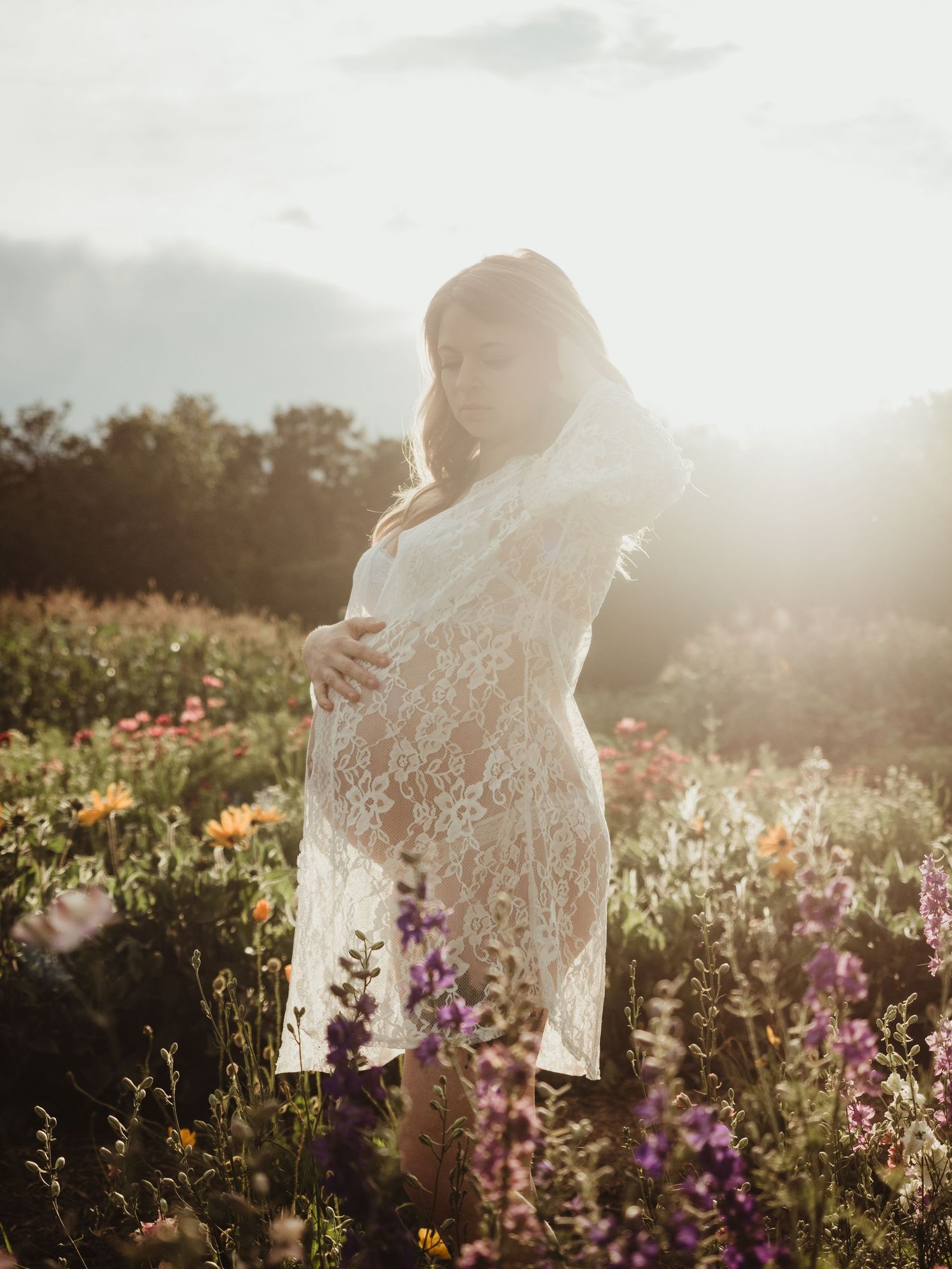 Maternity session in wildflower field at sunset