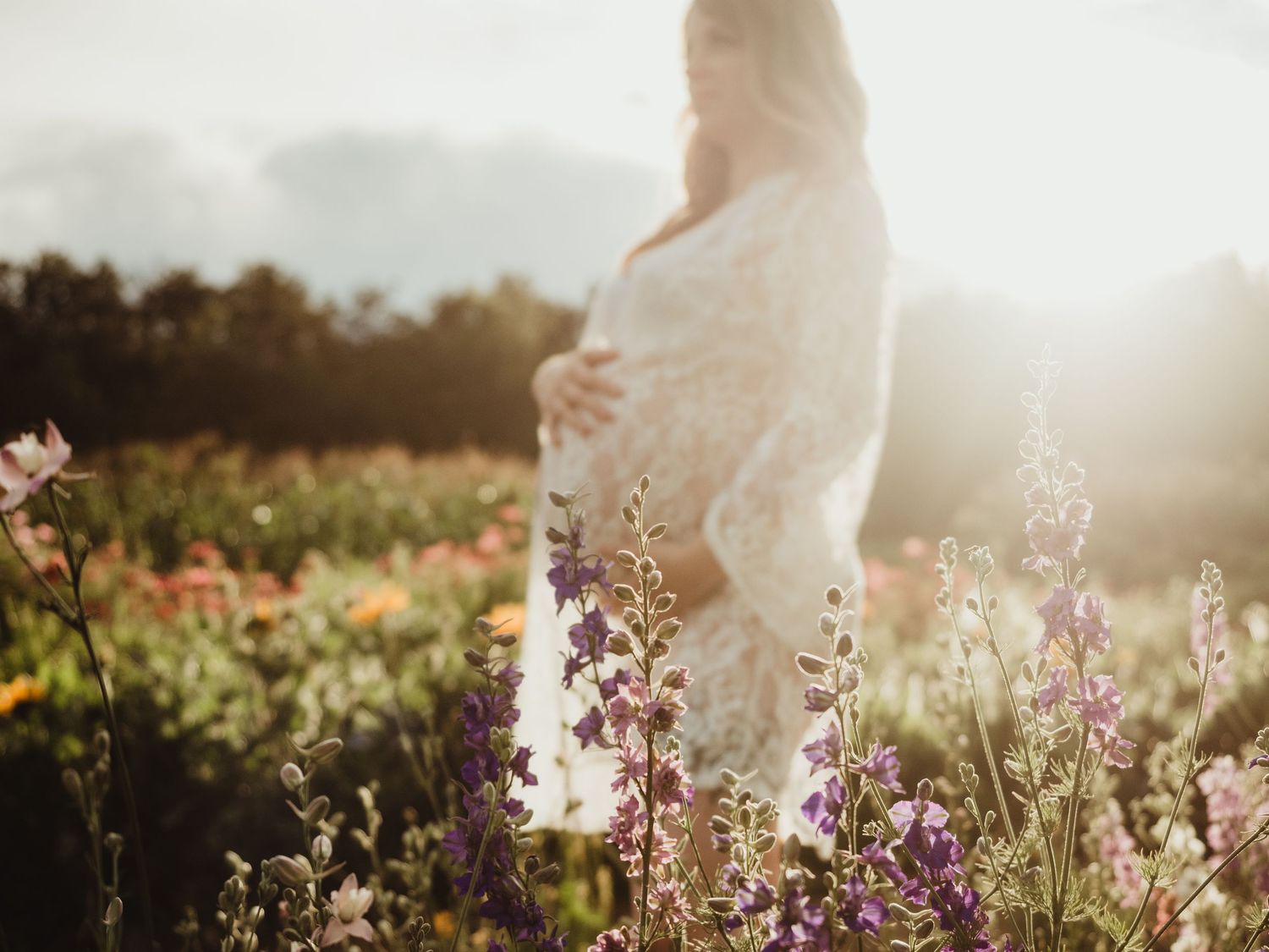 Maternity session in wildflower field at sunset