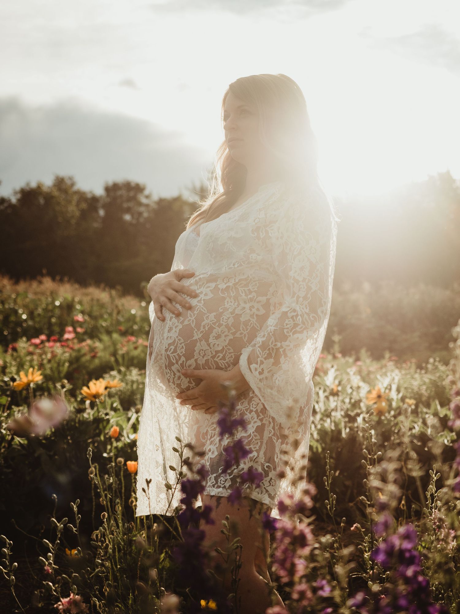Maternity session in wildflower field at sunset