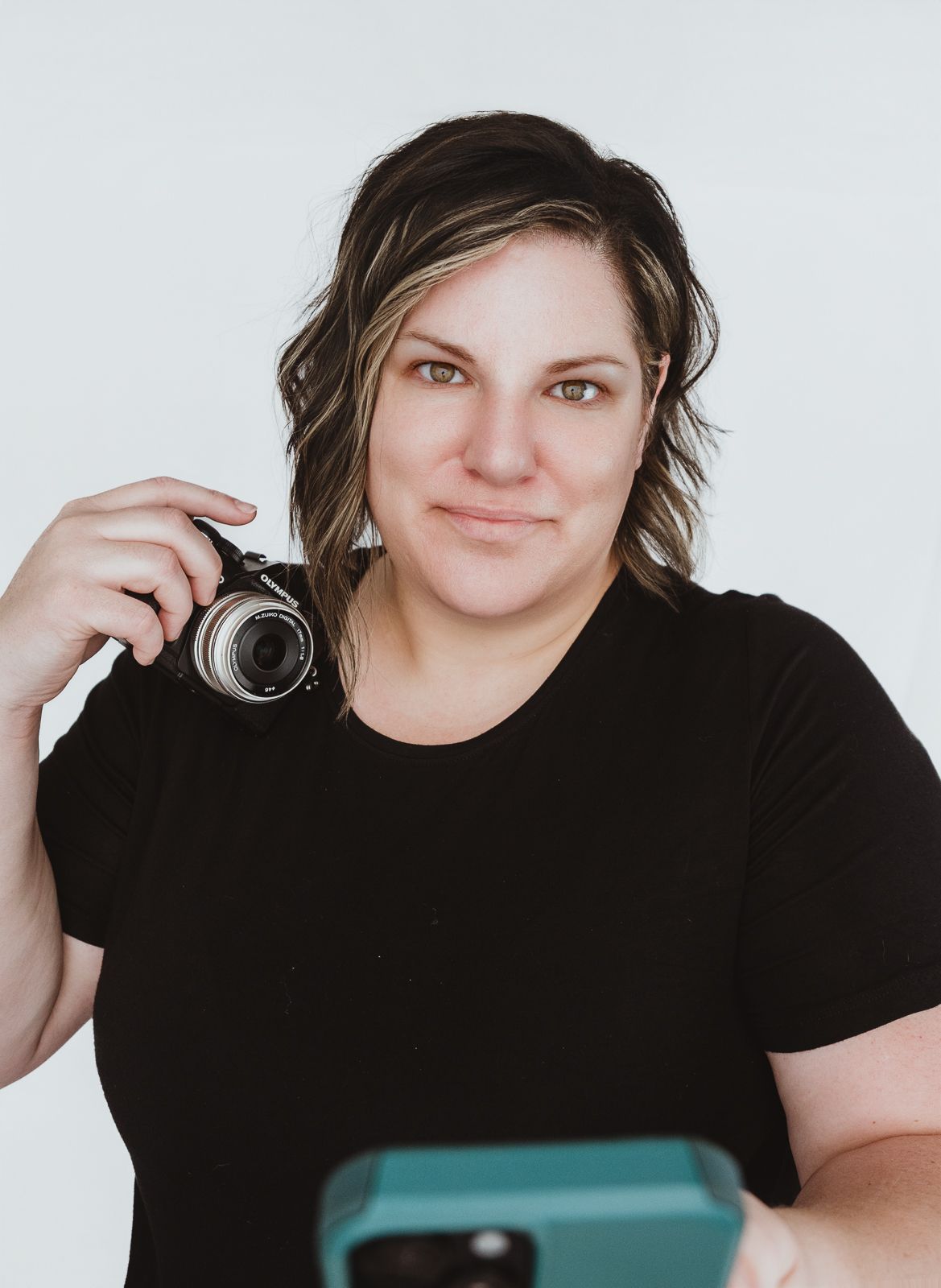 Coral Konanz, Spruce Grove photographer, smiling while working with her camera during a branding photography session.