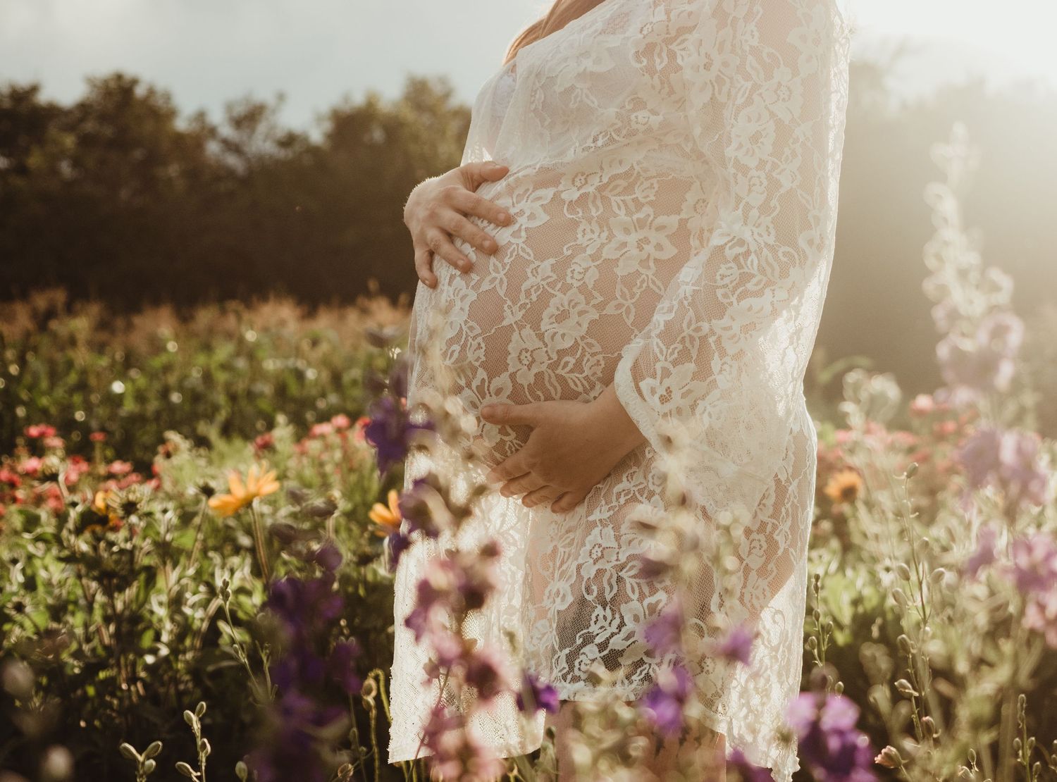 Maternity session in wildflower field at sunset