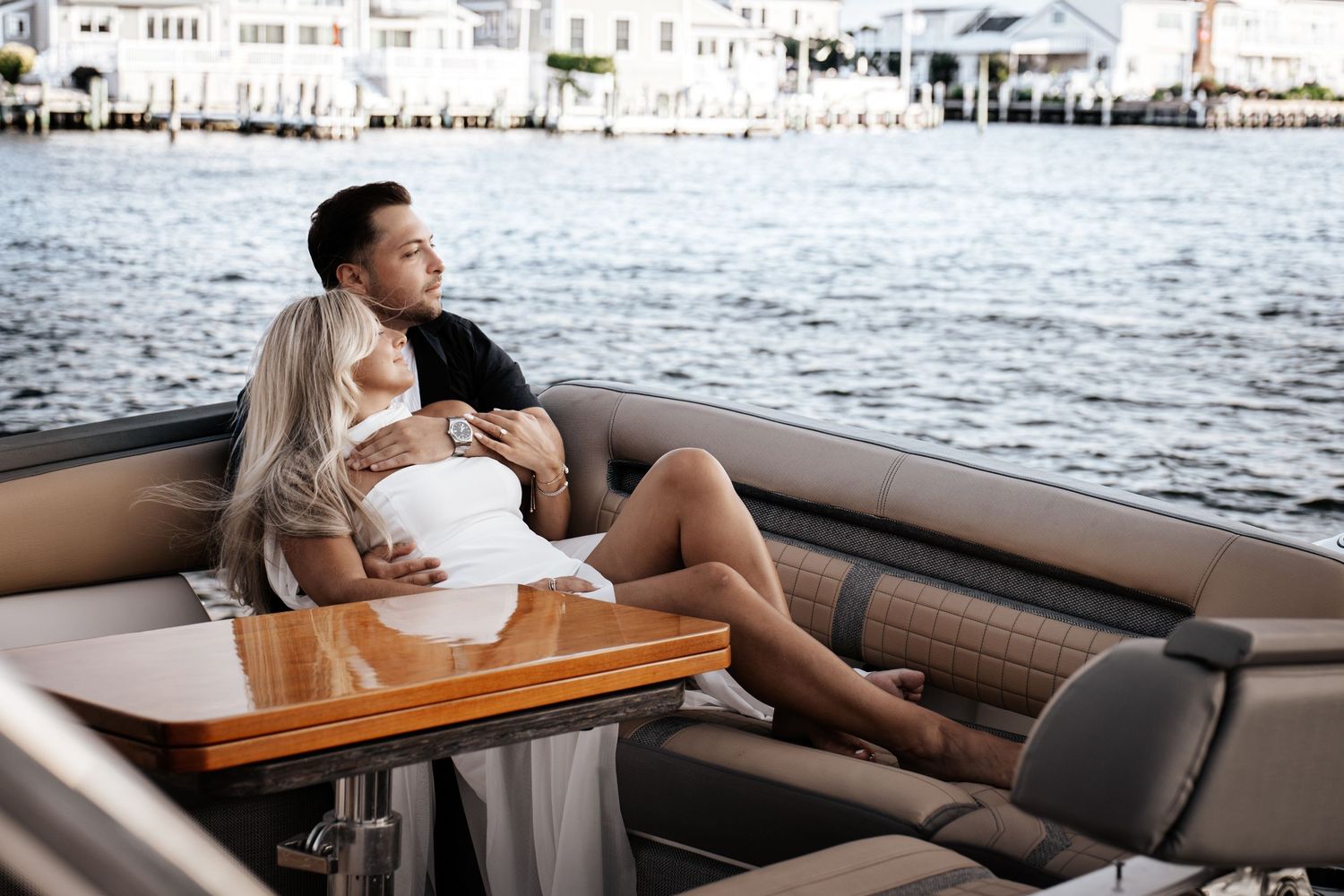 Couple relaxing together on a luxury boat with a scenic waterfront view in the background in New Jersey.