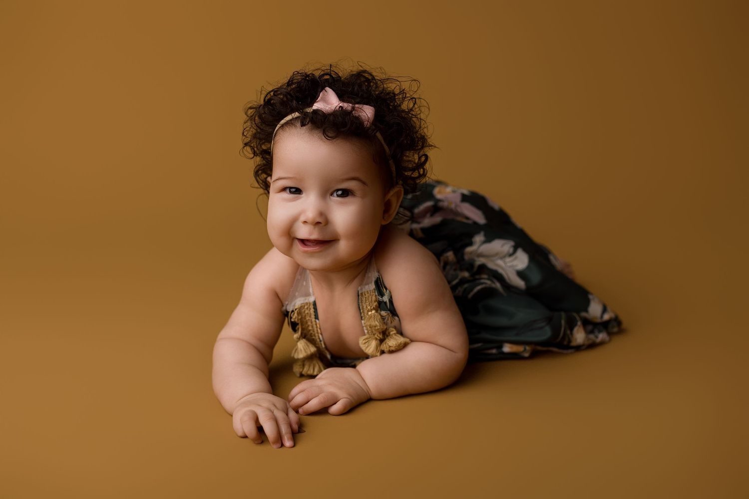 A baby lies on a brown backdrop in a series of progressive photos showing different expressions and poses.