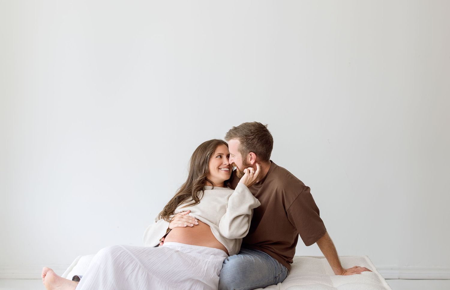 A loving couple shares tender moments in a series of romantic black and white maternity photographs.