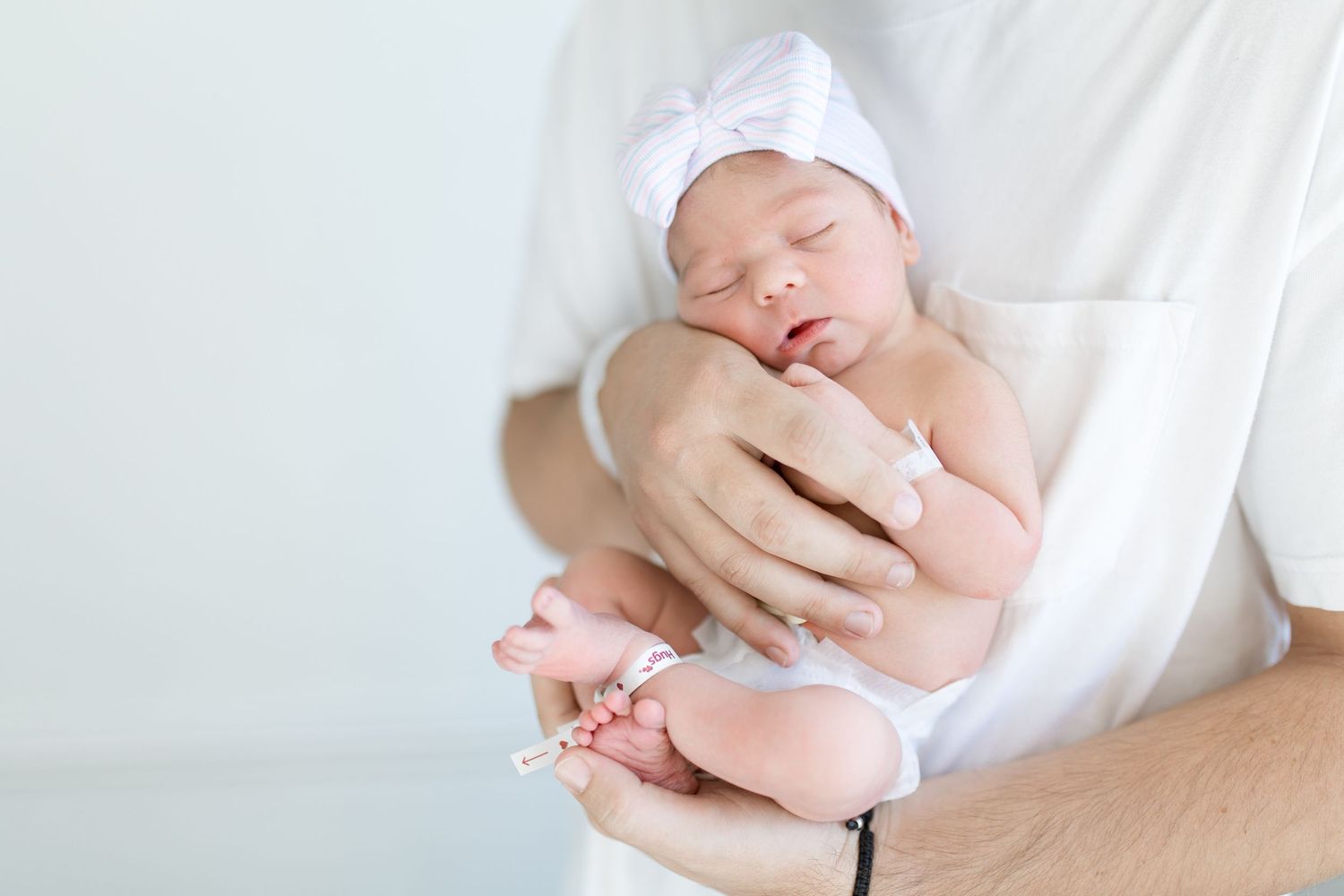 Newborn baby wrapped held in parent's arms during intimate photoshoot during Fresh 48 session in Beaumont hospital.