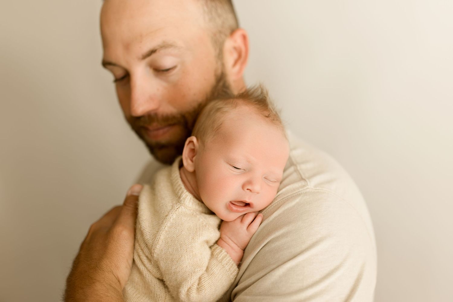 A parent and baby share tender moments in a series of warm, neutral-toned portrait photographs.