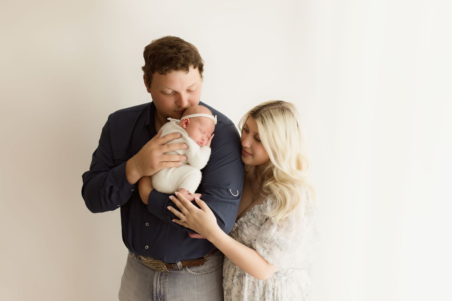 Intimate family photo session showing tender embraces against a minimal white background.