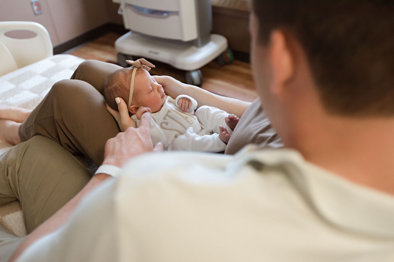 Mom and dad holding newborn baby in their hospital bed during their Fresh 48 session in Beaumont, TX.