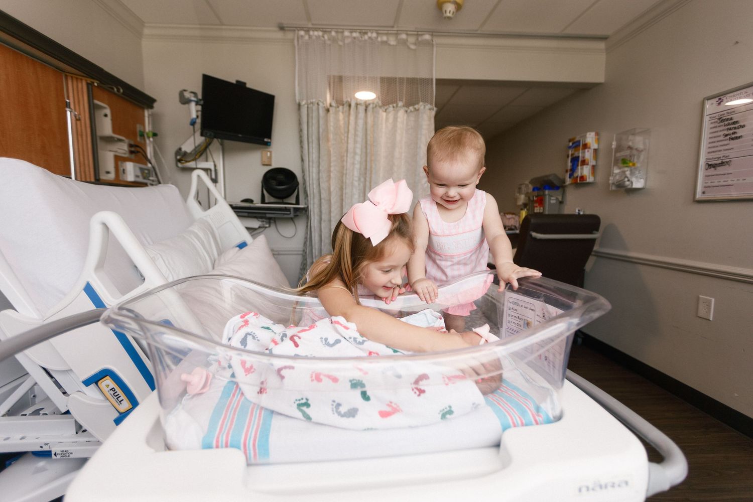 Hospital room photos showing newborn baby in bassinet with sister for Fresh 48 session.