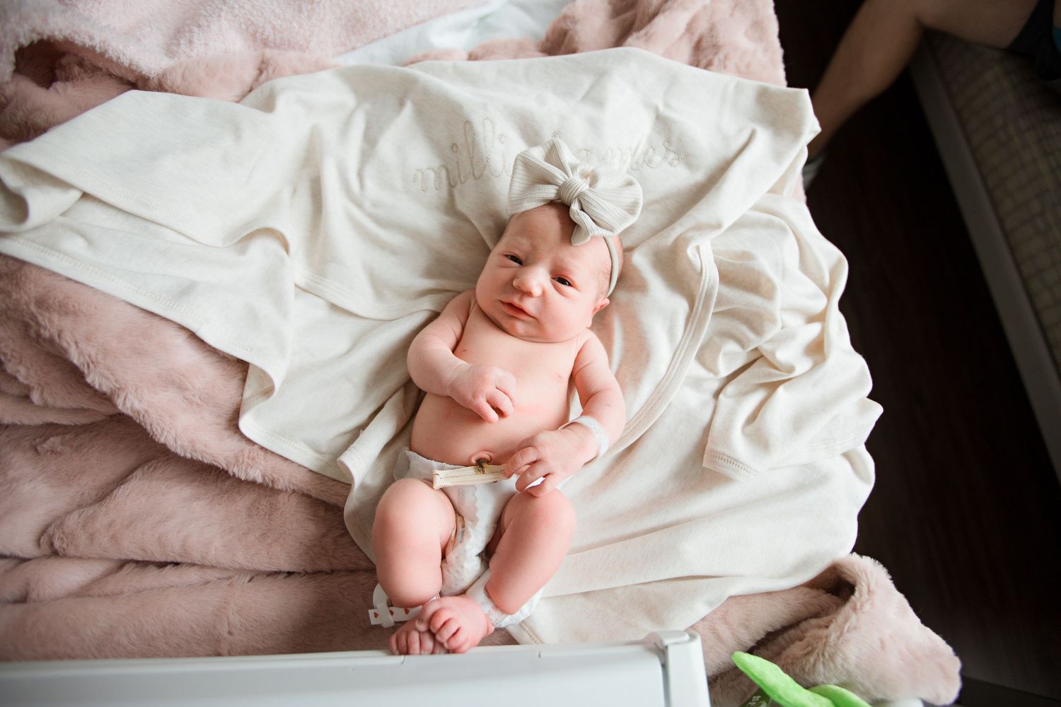 Newborn baby wrapped in soft white blankets while sleeping peacefully during Fresh 48 session in Beaumont hospital.