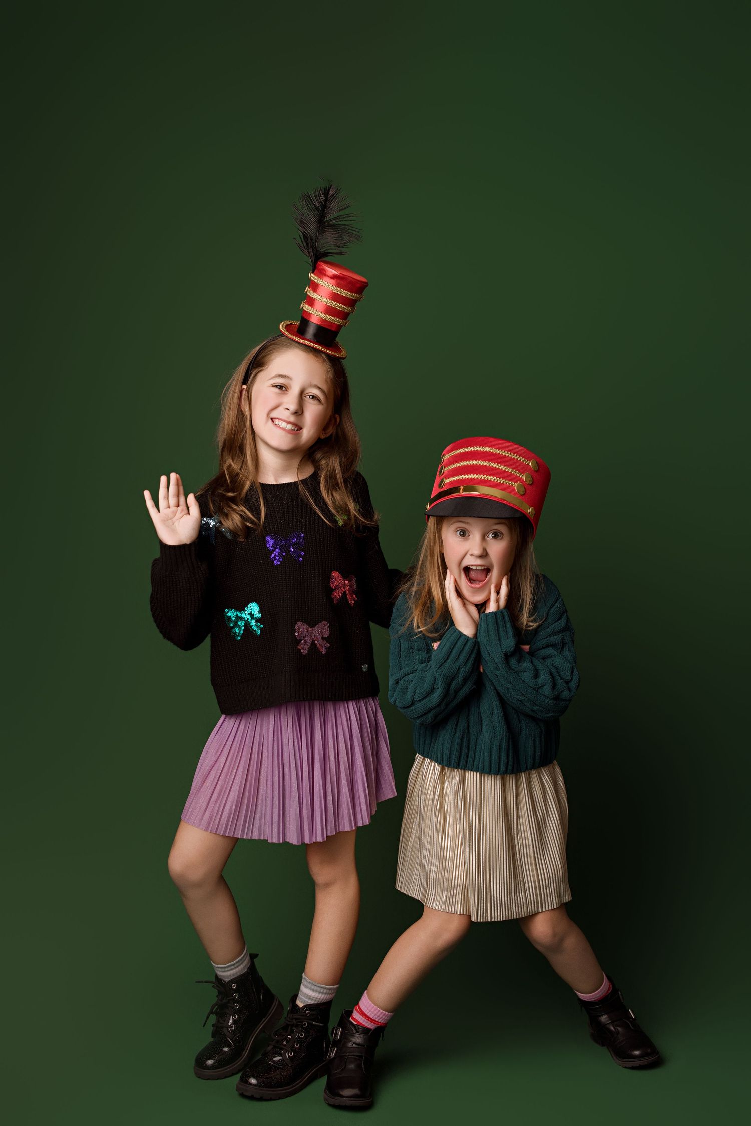 A playful fashion photo series against a dark green backdrop shows two children in coordinated outfits and striped socks.