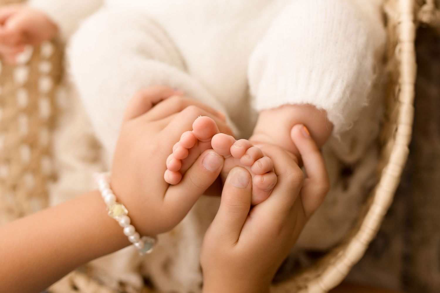Close-up detailed shots of tiny baby feet and hands in sepia tones.