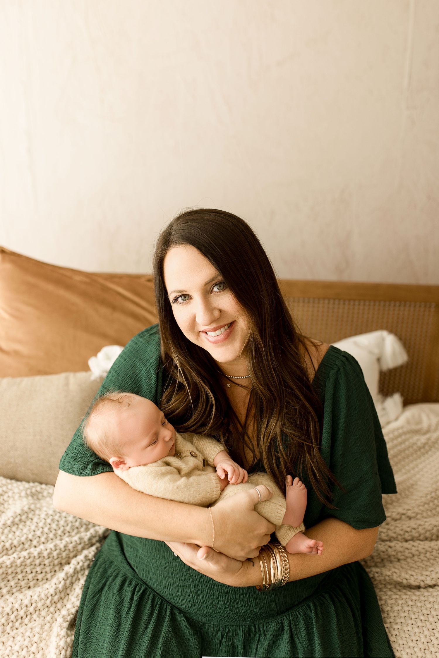 A series of tender moments captured between parent and newborn on a cozy bed with textured bedding.
