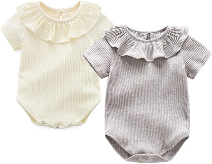 Ruffle collar ribbed onesies and tops for babies in soft cream and gray colors laid out on white background.