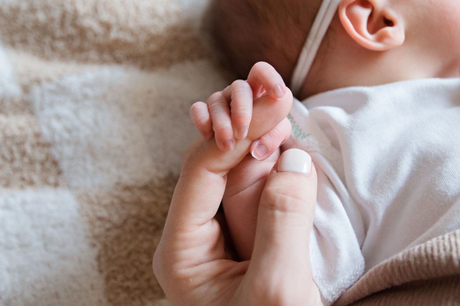 Detailed shots of newborn baby's tiny fingers and toes in white clothing during Fresh 48 session in Beaumont hospital.