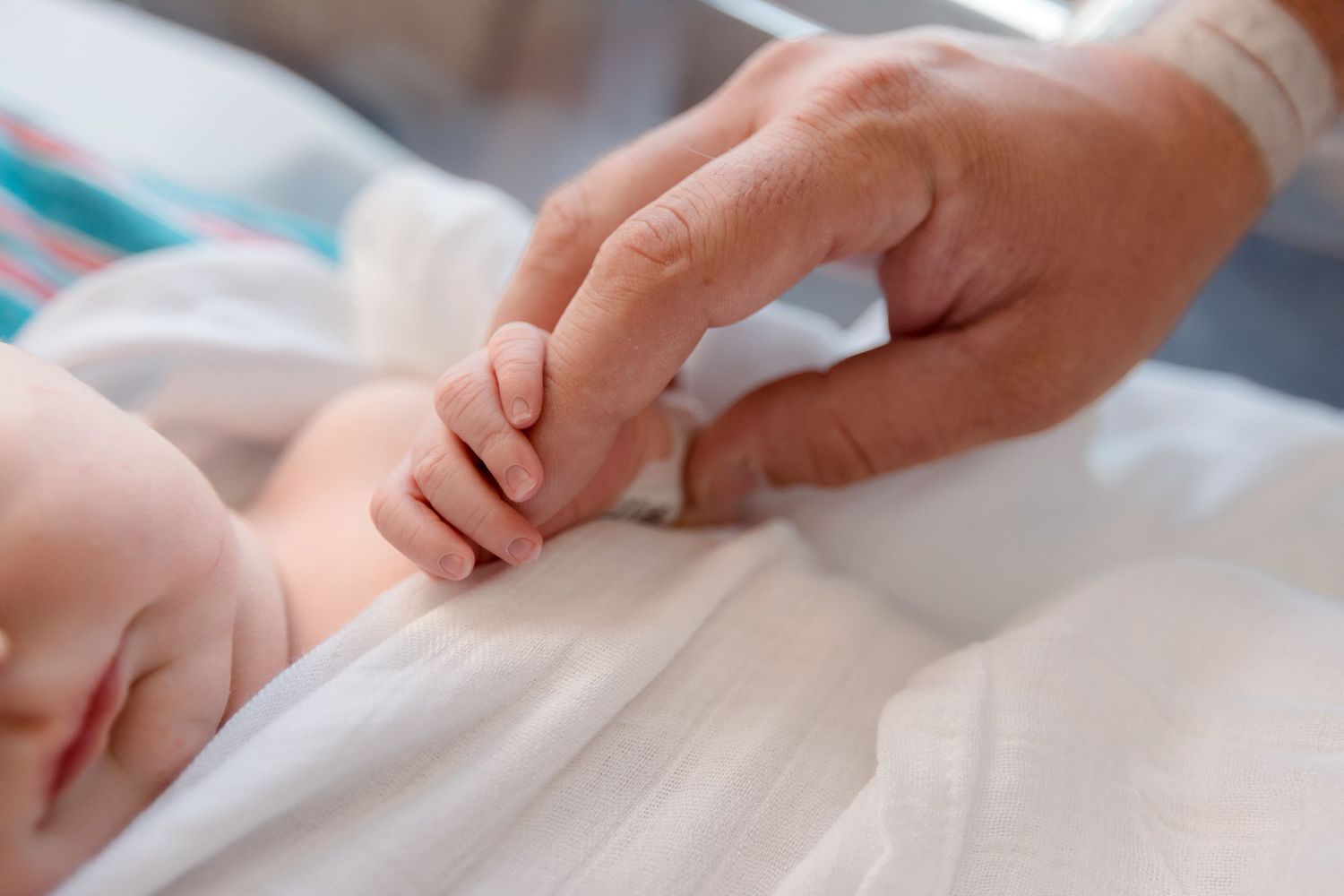 Dad and newborn hand during Fresh 48 session in Beaumont hospital.