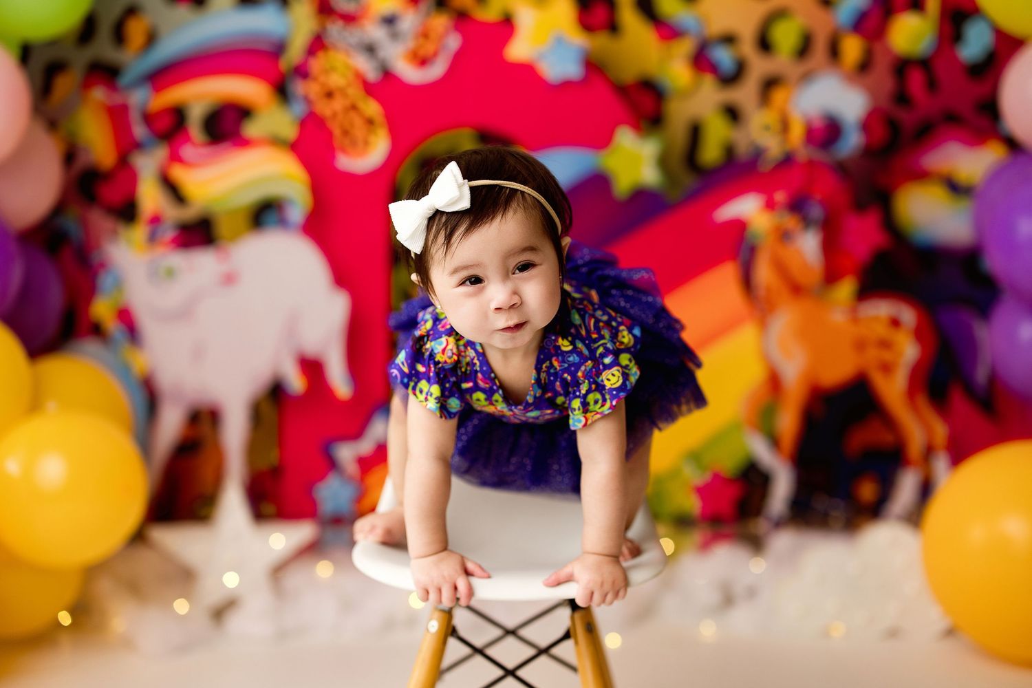 A whimsical children's party setup with colorful balloons, toys, and festive decorations against a bright backdrop.