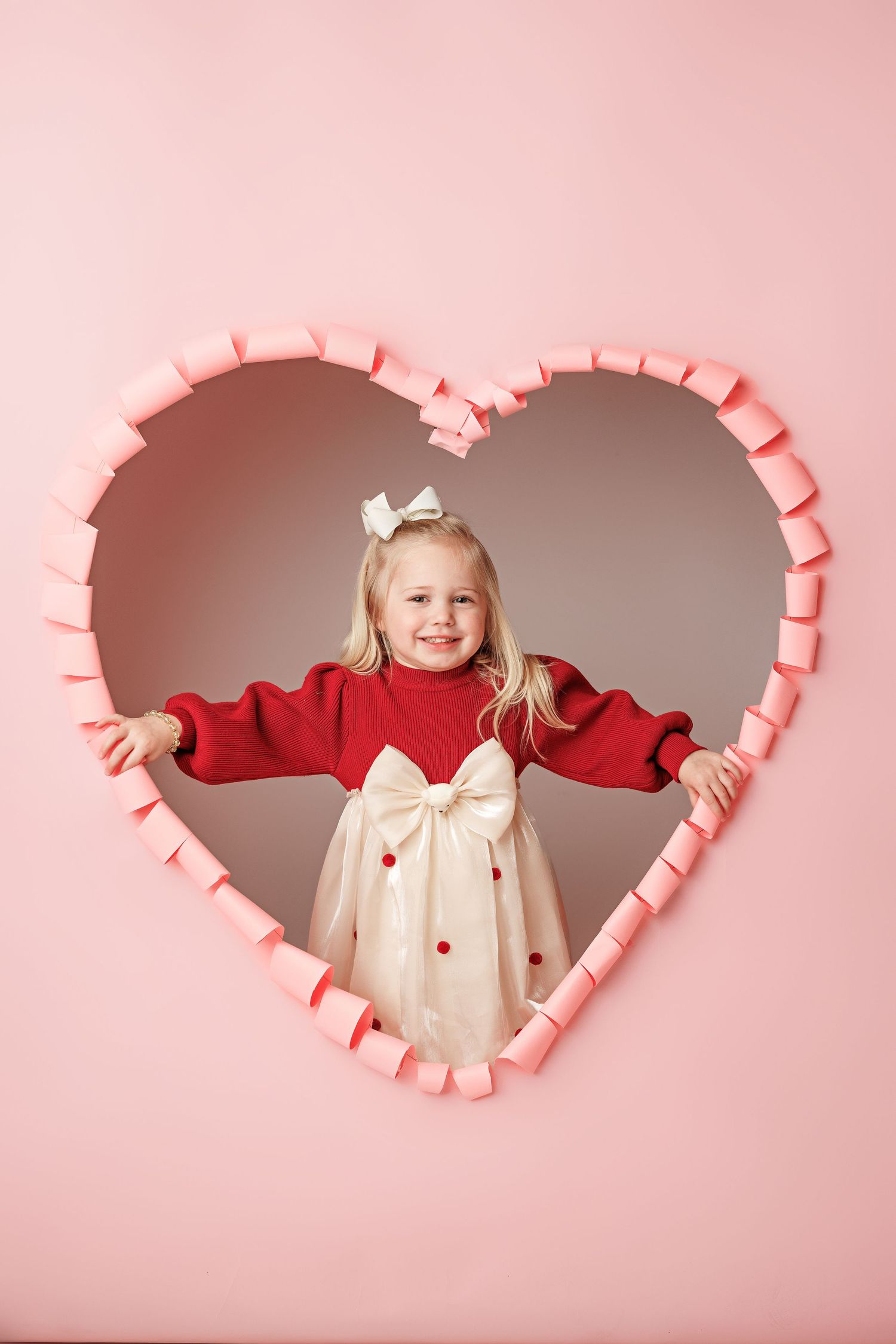 Valentine's themed portrait in pink heart-shaped frame with red and white outfit.