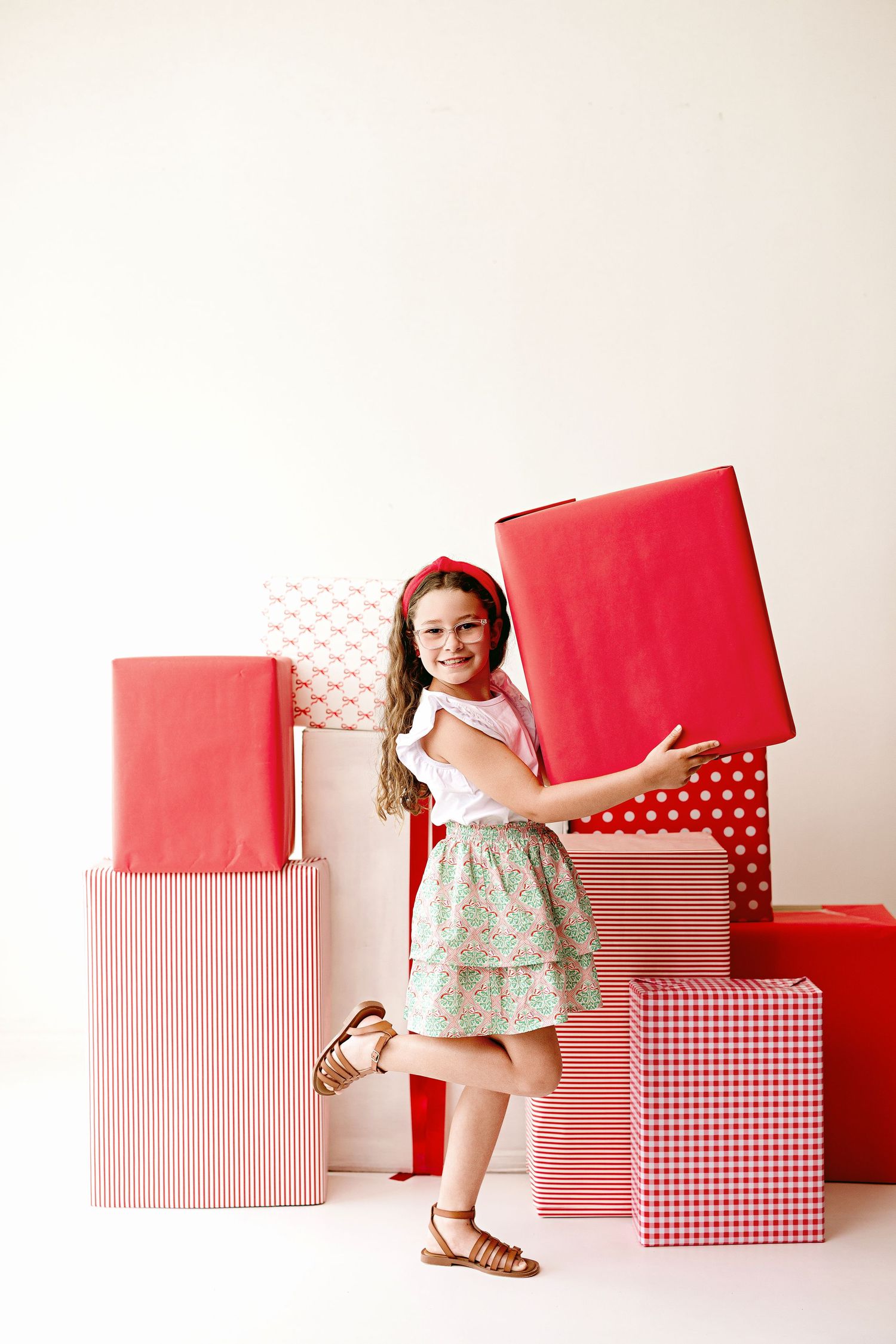 A series of pink and red patterned gift boxes arranged in a minimalist style against a white background.