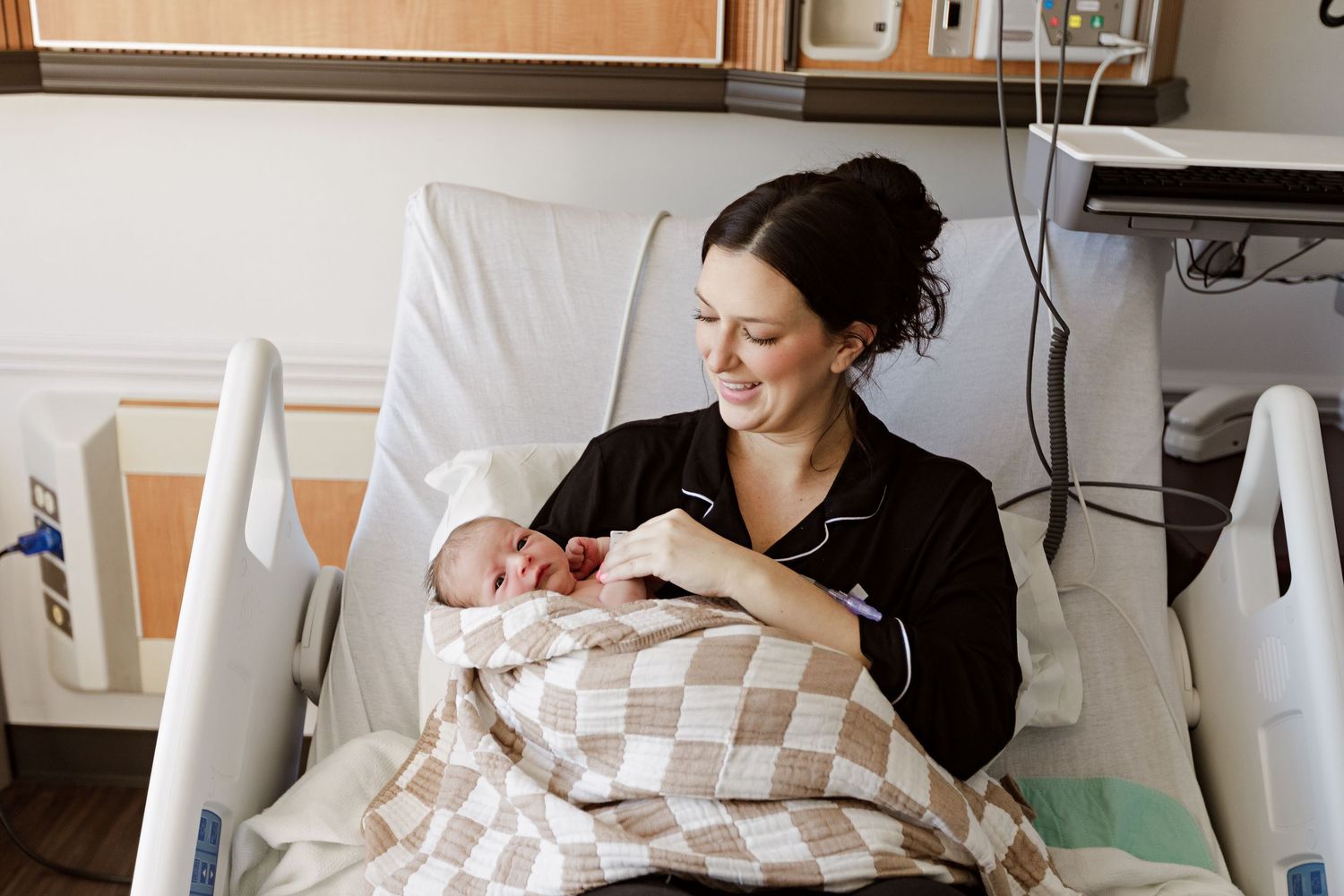 A peaceful moment in a hospital room as a new baby rests in a checkered blanket during Fresh 48 session in Beaumont hospital.