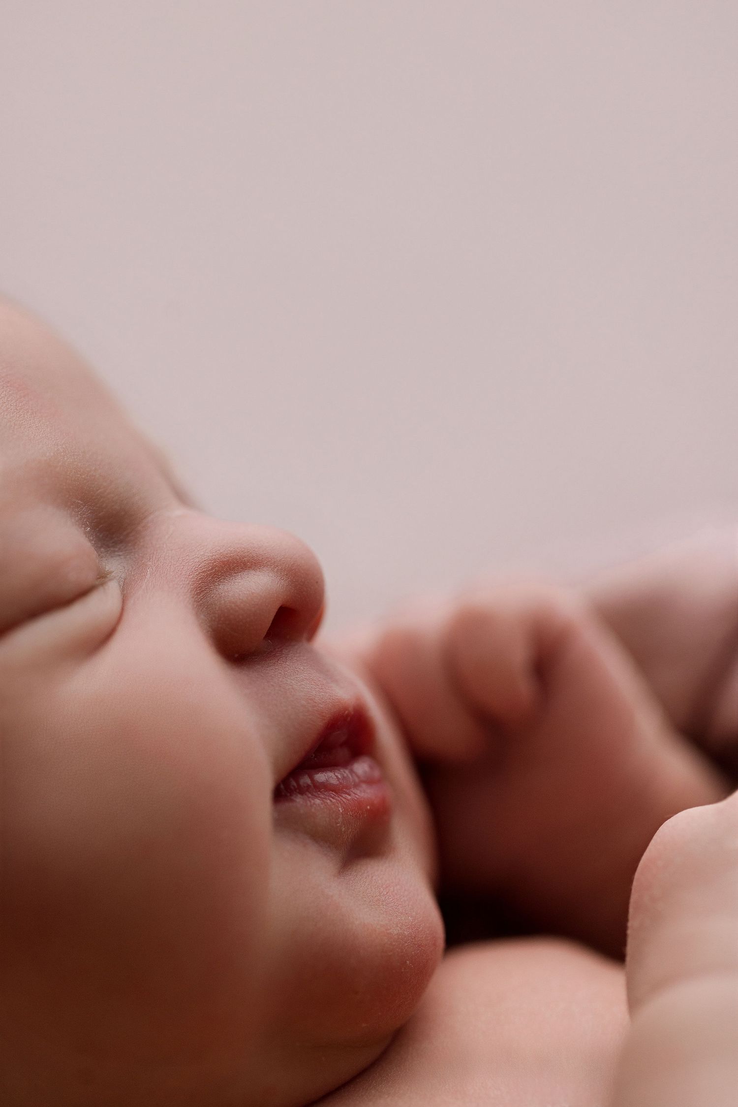 Close up macro shot of two people kissing in soft lighting with shallow depth of field.