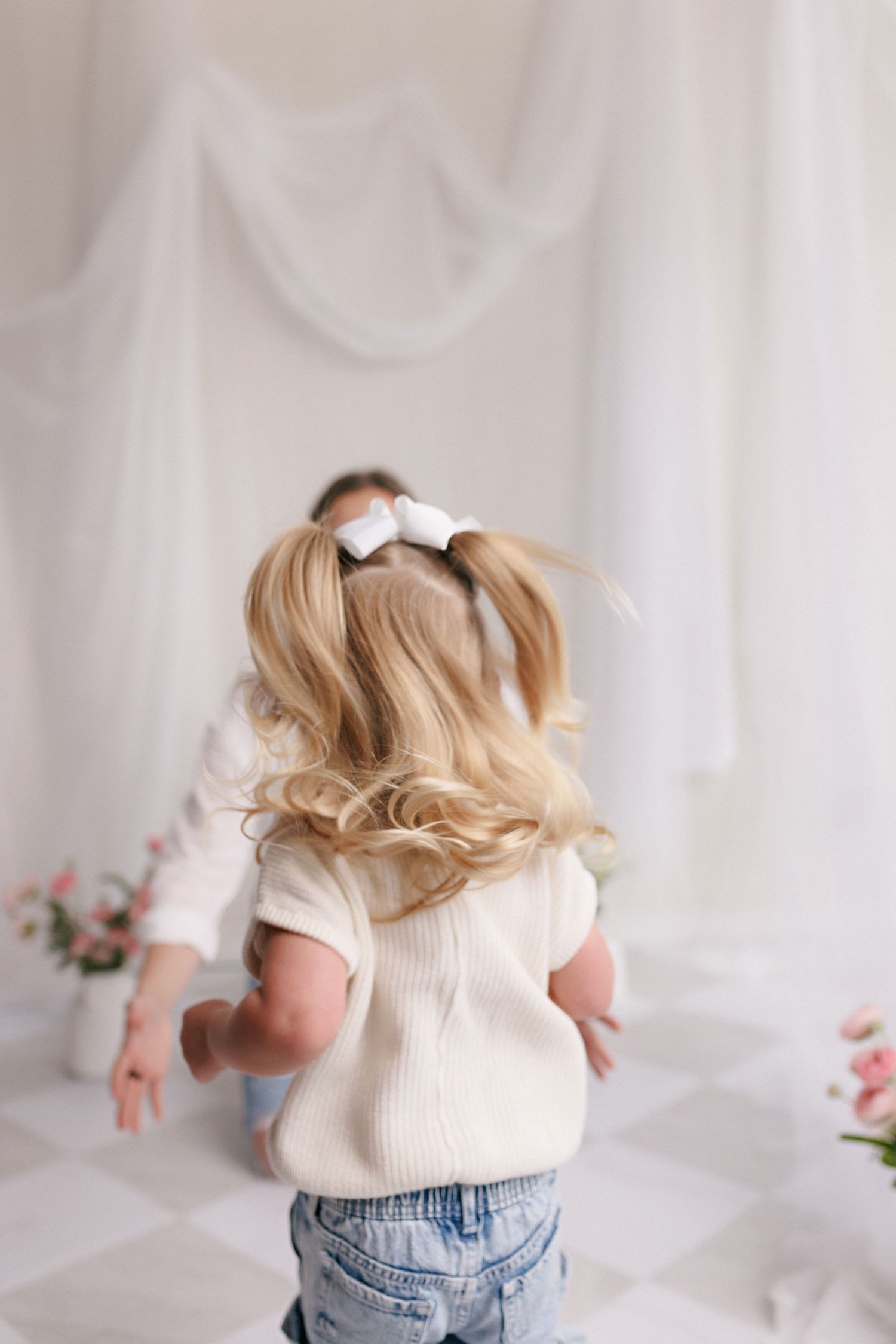 Parent and toddler in matching white tops and jeans during mommy and me session with Bree Elle Photography in Port Neches, TX.