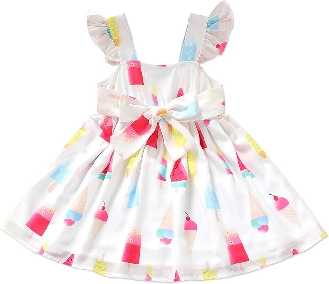 Multiple white baby dresses with colorful polka dot patterns arranged in a line on display.
