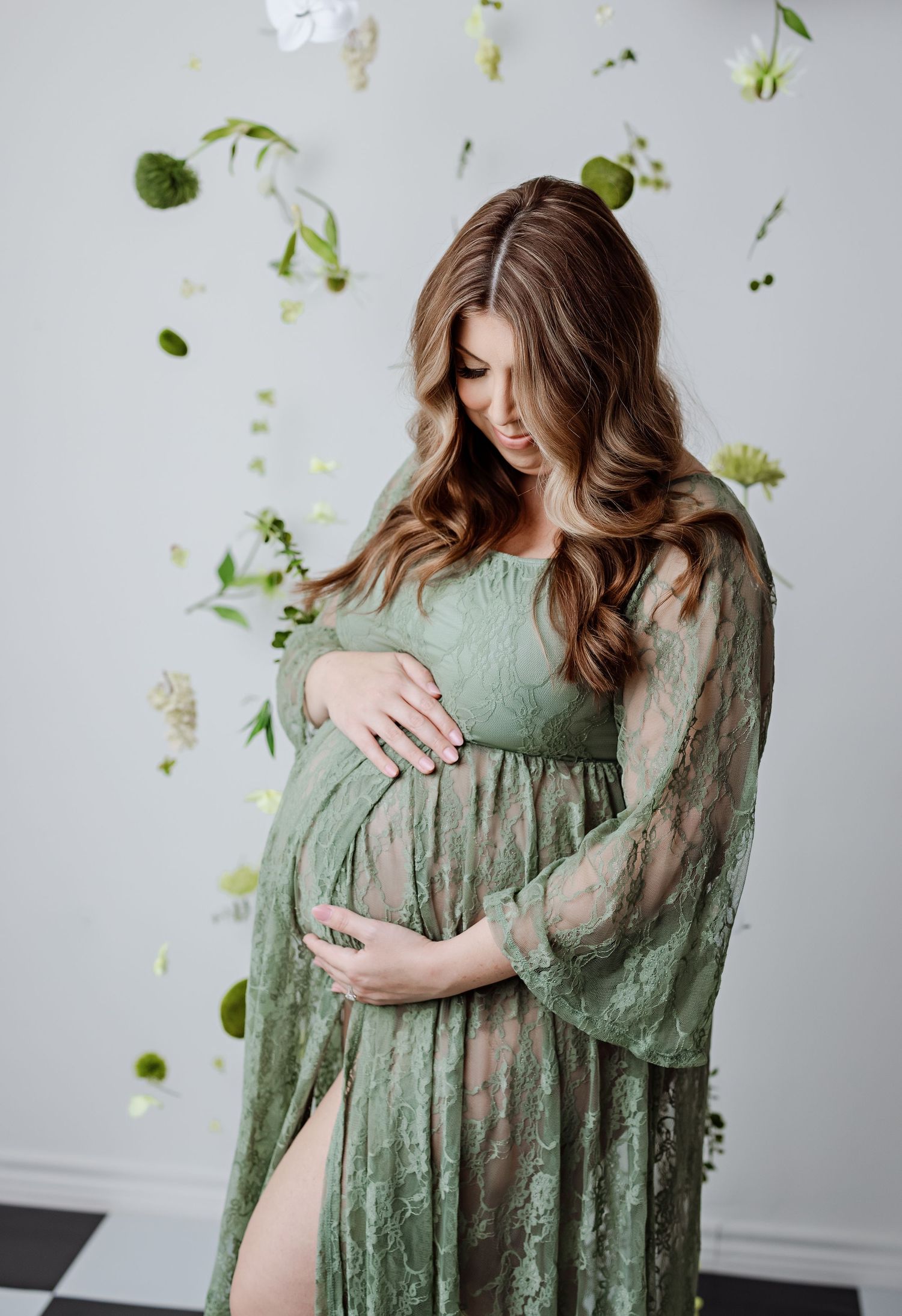 Artistic maternity photo with floating greenery and sage green lace gown with Bree Elle Photography in Lumberton, TX.