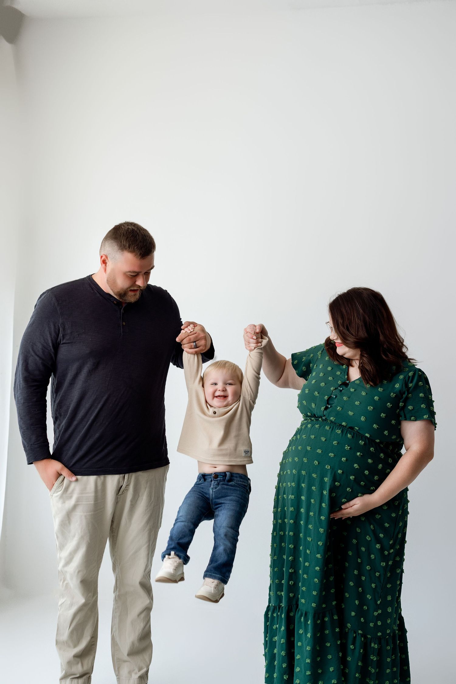 Four sequential photos showing a tender moment between two people dressed in green and black against a white wall.