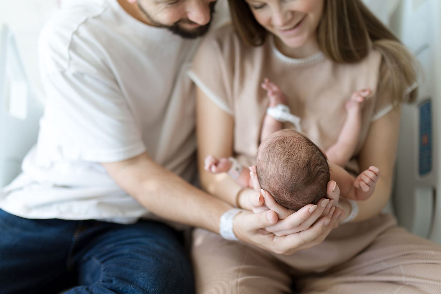 Parents tenderly hold their newborn baby together during Fresh 48 session in Beaumont hospital.