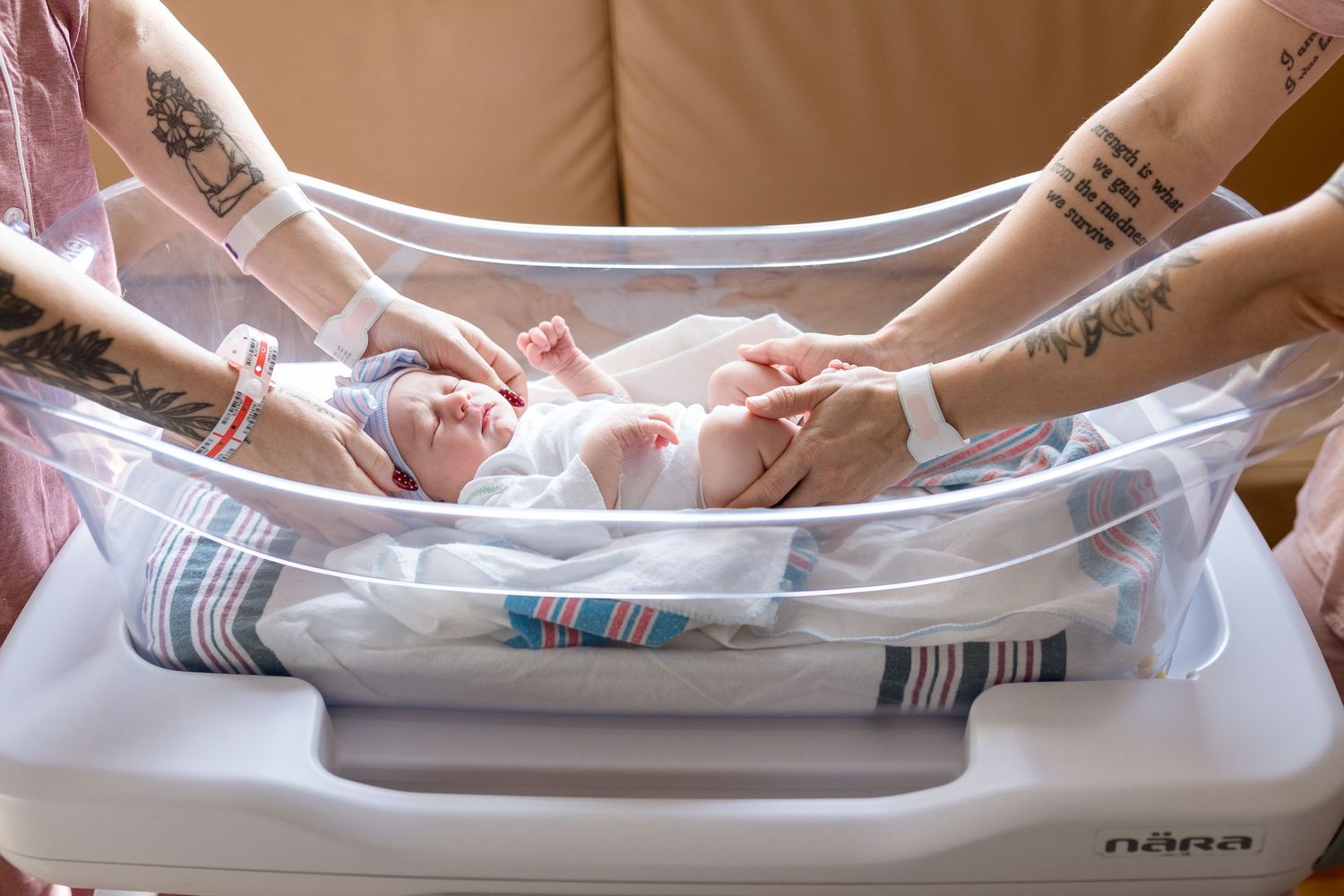 Parents touching their newborn baby in a bassinet during Fresh 48 session in Beaumont hospital.