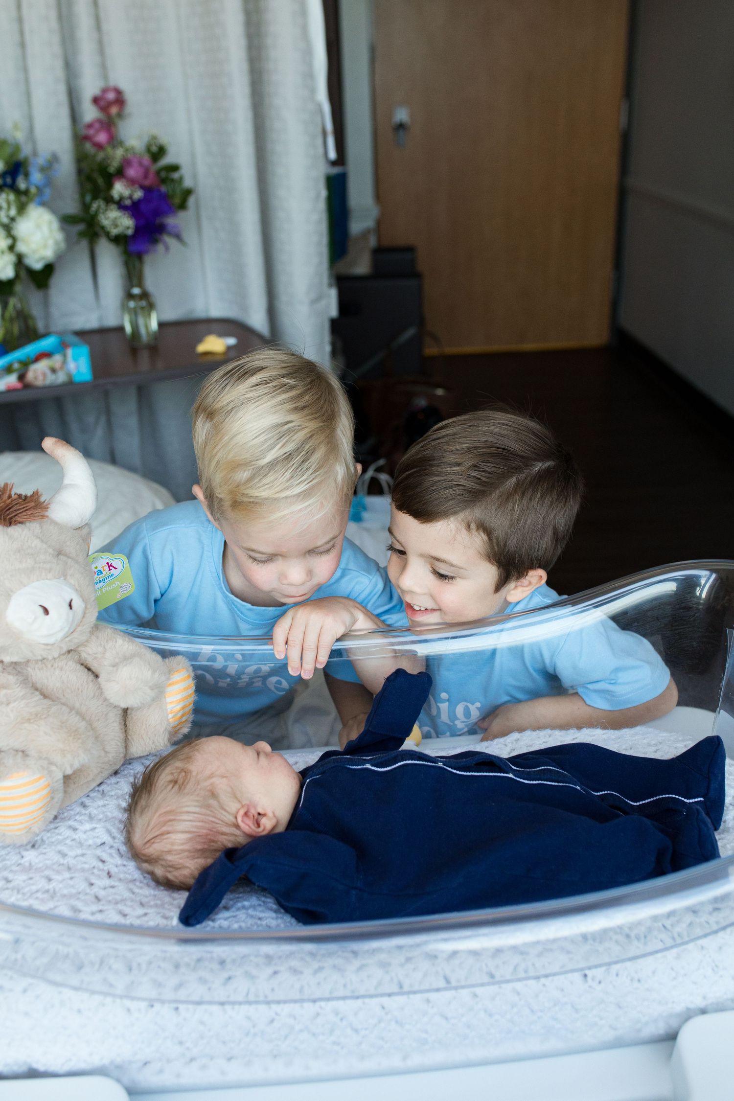 Older brothers meeting their newborn baby during Fresh 48 session in Beaumont, TX at St. Elizabeth with Bree Elle Photography.