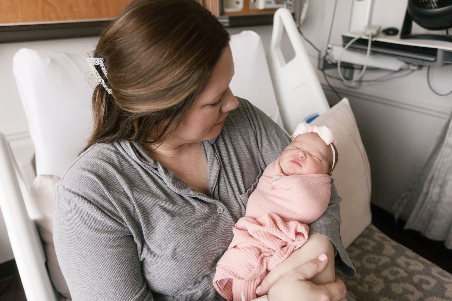 A tender moment between parent and newborn baby in a hospital room setting during Fresh 48 session in Beaumont hospital.
