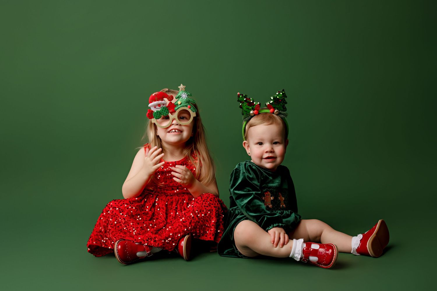 Holiday-themed studio portraits featuring red and green festive outfits against a dark backdrop.