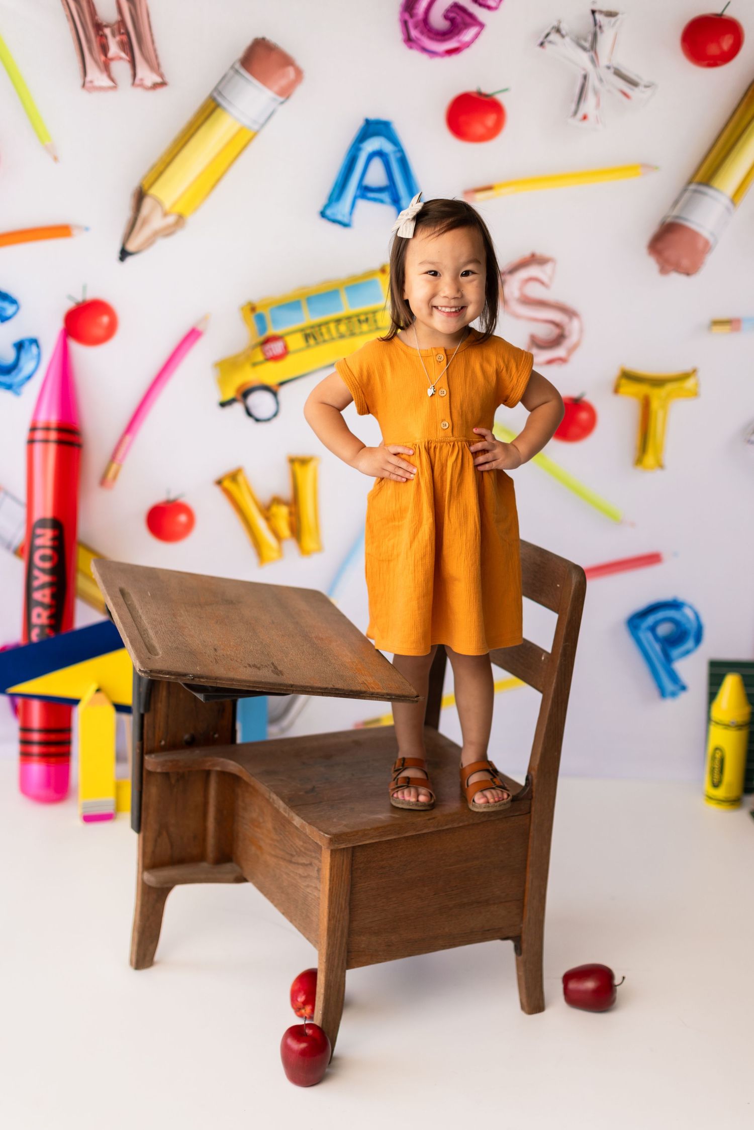 Creative school photography setup with oversized pencils and educational elements on wall.