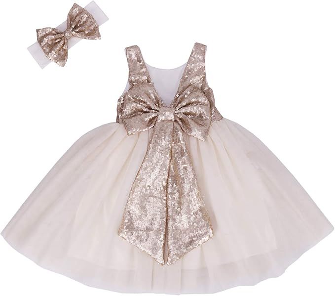 White tulle baby dress with champagne sequin bow and matching hair accessory for special occasions.