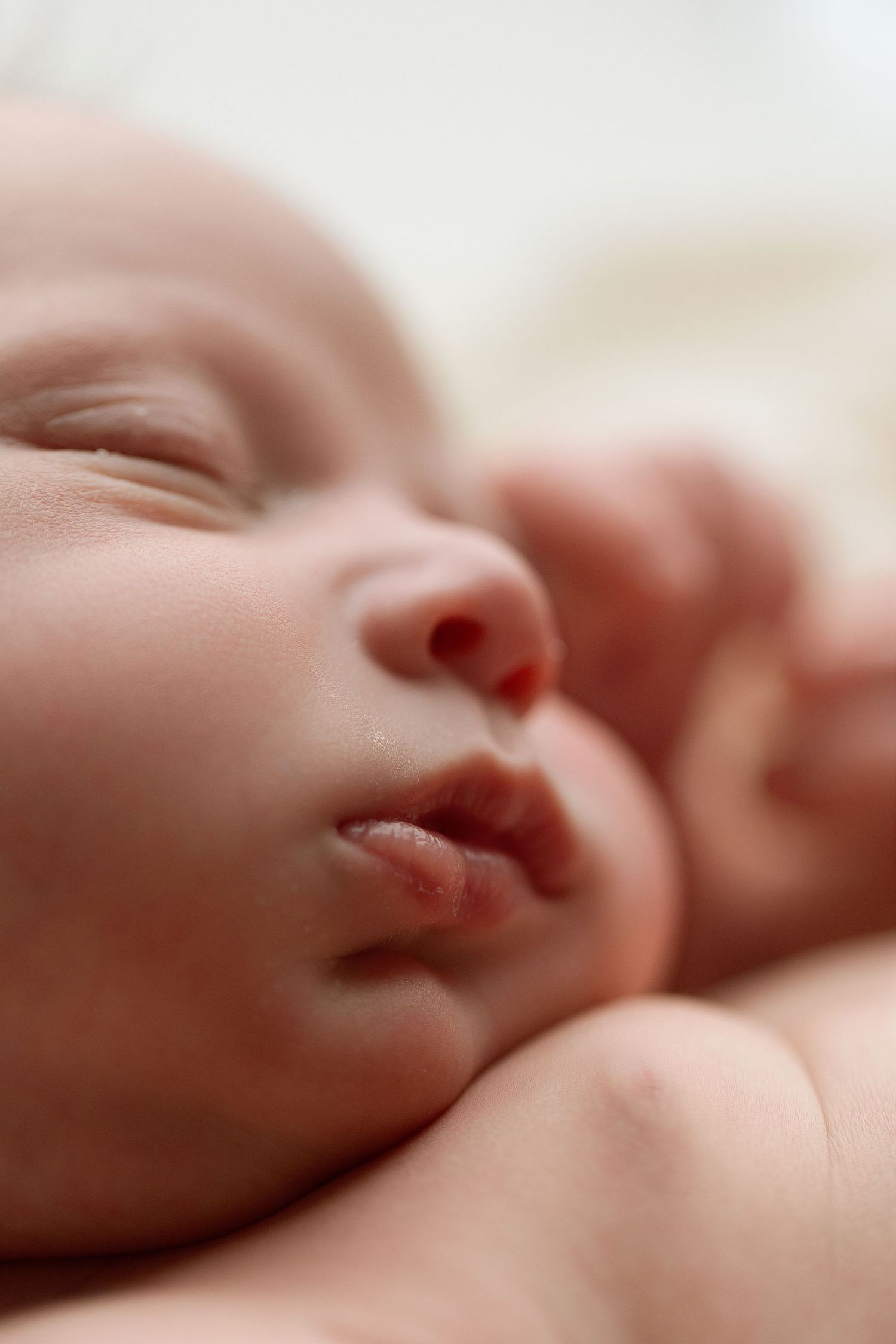 Close-up macro shot of a sleeping newborn baby's face showing peaceful expression and delicate features.